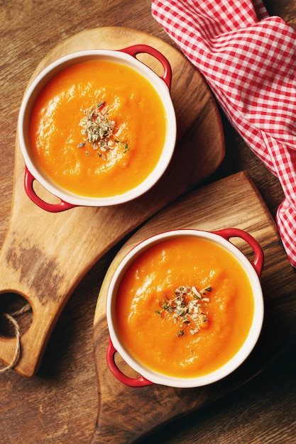 Foto kürbiscremesuppe in kleiner saucenpfanne mit kürbiskernen und thymianblättern