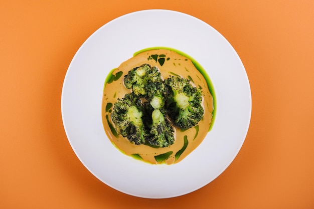 Kürbiscremesuppe mit Brokkoli auf Teller