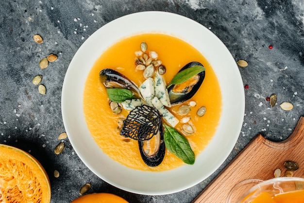 Kürbiscremesuppe mit Muscheln, Blauschimmelkäse, Schimmel. Köstliches ausgewogenes Lebensmittelkonzept. Ansicht von oben.