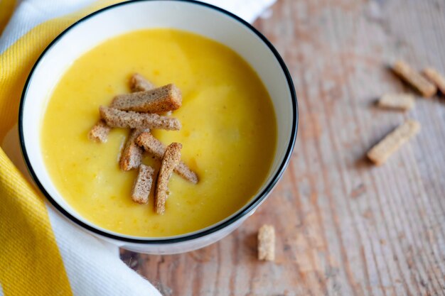 Kürbiscremesuppe mit Semmelbröseln auf einem hölzernen Hintergrund Draufsicht