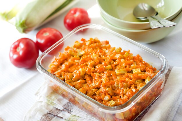 Kürbiseintopf mit Karotten und Tomaten in einer quadratischen Glasschale