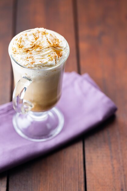 Kürbisgewürz Latte in einem Glasbecher