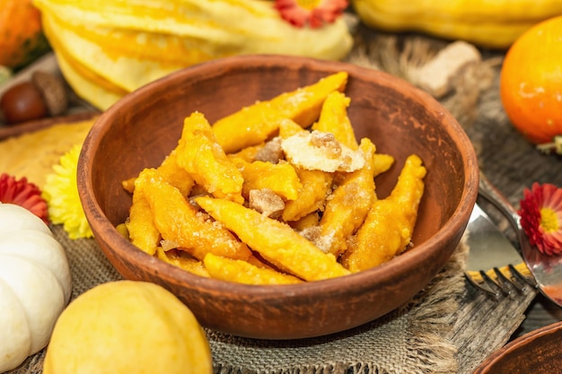 Kürbisgnocchi oder italienische Knödel. Gesundes vegetarisches Kürbisgericht mit Hüttenkäse. Herbstdekor mit Herbstlaub, ganzen Kürbissen, Blumen und Gewürzen. Alter hölzerner Hintergrund, selektiver Fokus