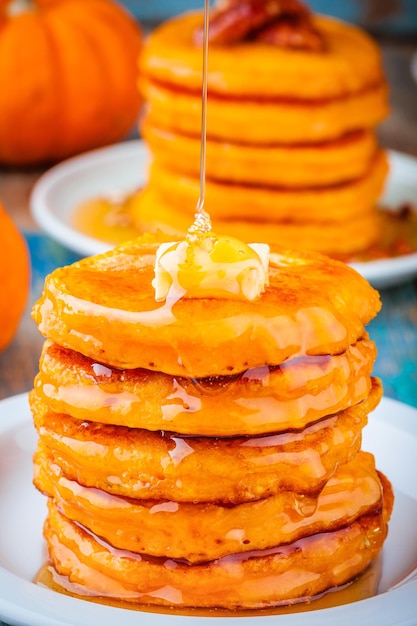 Kürbispfannkuchen mit Honig und Butter auf Holztisch