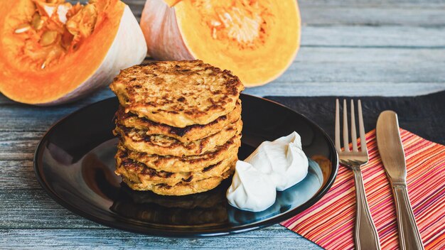 Kürbispfannkuchen mit Naturjoghurt auf Holztisch serviert