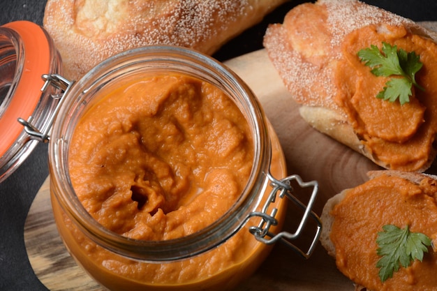 Kürbispüree (Kürbiskaviar) im Glas und auf Brotscheiben.Hausgemachter Gemüsekaviar