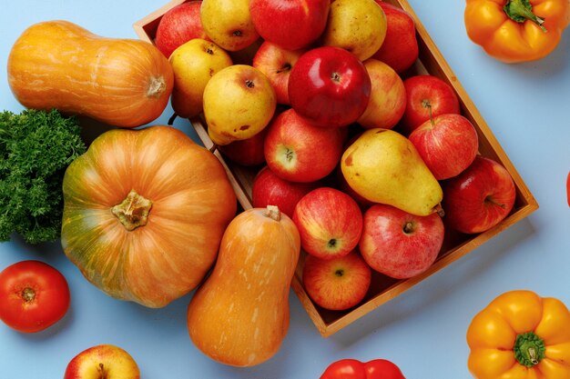 Kürbisse, Äpfel und Paprika Zusammensetzung auf blauer Oberfläche