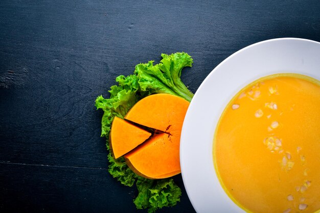 Kürbissuppe auf einem hölzernen Hintergrund Ansicht von oben Freier Platz für Text