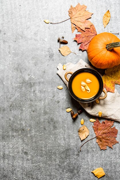 Kürbissuppe im Herbststil aus einem reifen Kürbis auf dem Steintisch