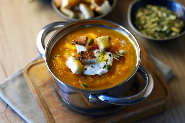 Kürbissuppe in einem Topf mit Croutons