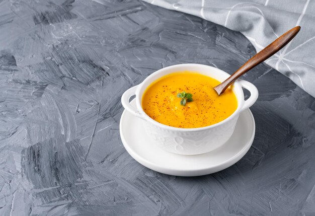 Kürbissuppe mit Croutons auf grauem Hintergrund mit Platz für Text