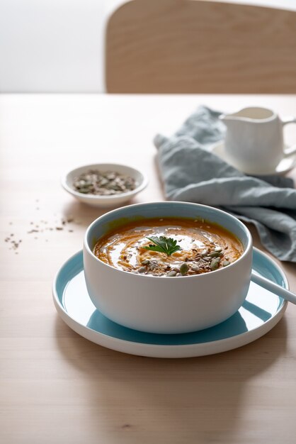 Kürbissuppe mit Kokosmilch und Samen in der blauen Schüssel