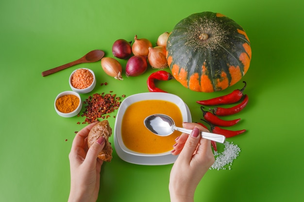 Kürbissuppe mit Zwiebeln und Pfeffer auf grünem schattenlosem Hintergrund