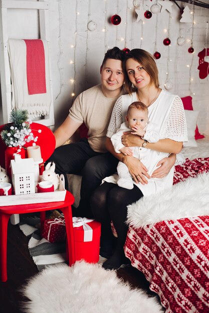 Küssen der Eltern mit dem Umarmen der Kinder am Weihnachten.