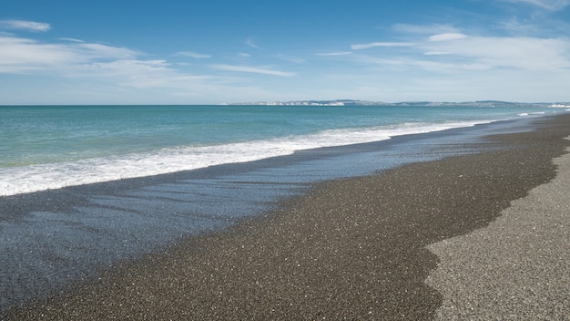 Küstenlandschaft mit ruhigem Meer und Strand mit blauem Himmel im Hintergrund