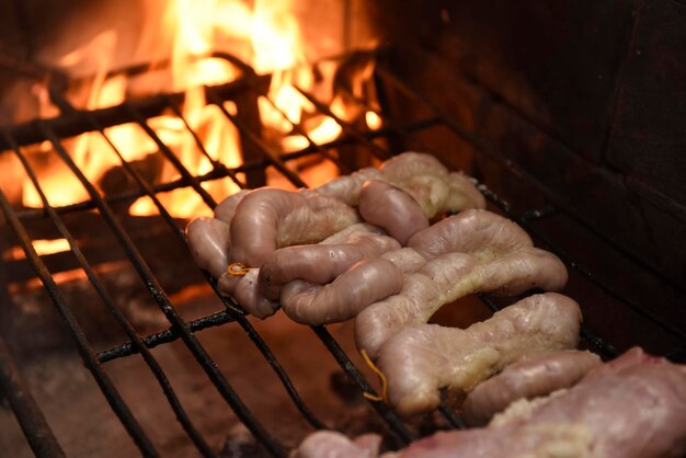 Kuhdarmen auf einem Holzbrett mit zubereiteten Zutaten, die zum Grillen bereit sind