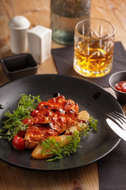 Kulinarisches Gericht Chicken Steak Restaurant mit schwarzem Geschirr Holztisch