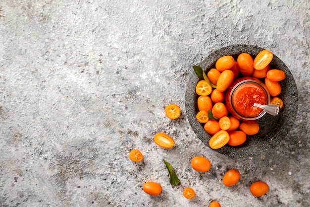 Kumquat Jam auf dem grauen Hintergrund. Helle Zitrusfrüchte.