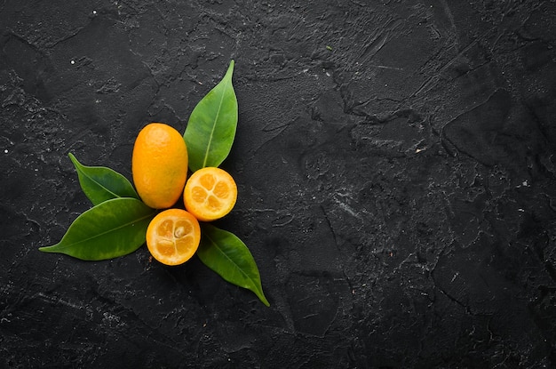 Kumquat sobre un fondo de piedra negra Cítricos Vista superior Espacio libre para su texto