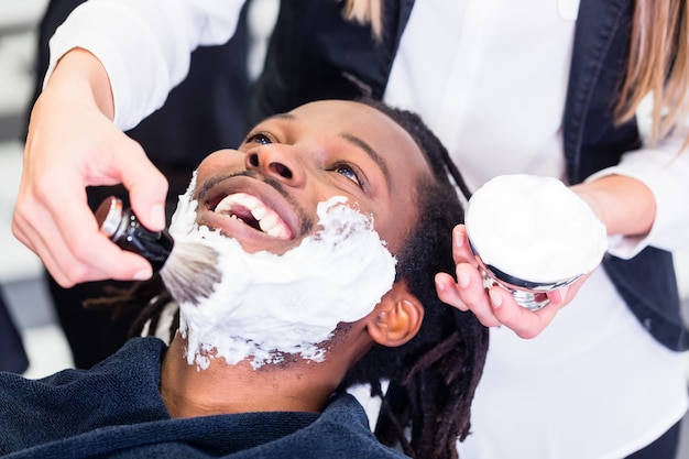 Kunde im Friseursalon mit Rasierschaum