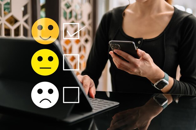 Kundendienstbewertungskonzept Frau Zeigen Sie Gesicht Lächeln Emoticon Show auf virtuellem Bildschirm von Handblick auf Smartphone Tablet und LaptopxAxA