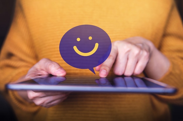 Kundenerlebniskonzept. Glücklicher Kunde, der Digital-Tablet zum Senden einer positiven Bewertung verwendet. Zufriedenheits-Online-Umfrage