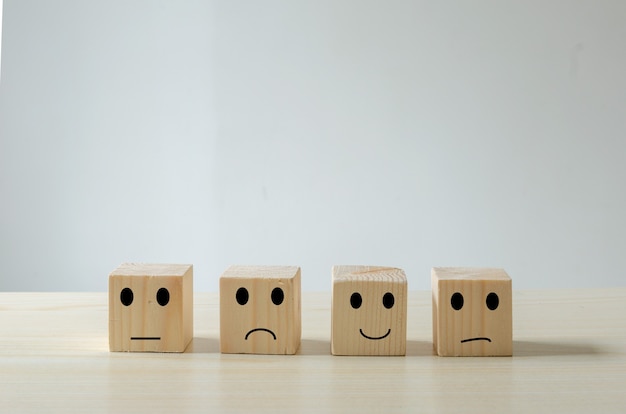 Kundenservice Bewertungen und Feedback Emotion Konzept Holzwürfel. Zufriedenheitsumfrage mit negativen, neutralen und positiven Gesichtsausdrücken