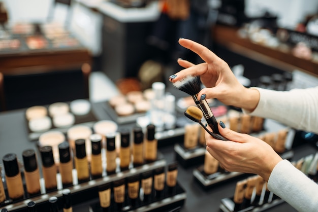 Kundin, die Bürsten im Make-up-Shop wählt