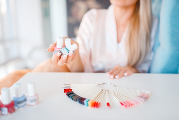 Kundin hält Nagellackflaschen