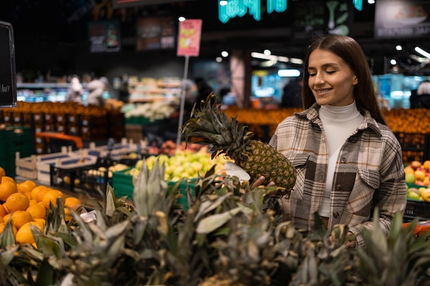 Kundin im Lebensmittelgeschäft kauft Ananas