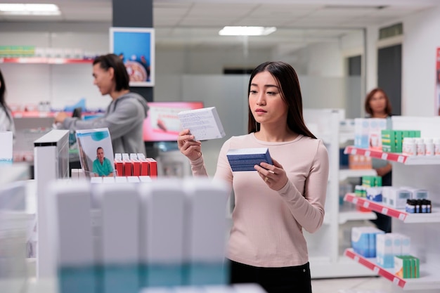 Kundin untersucht in Apotheken in Regalen verstreute Vitaminkisten und sucht nach verschreibungspflichtigen Medikamenten und damit verbundenen Gesundheitsdiensten. Kunde überprüft die Packungsbeilage von Medikamenten.