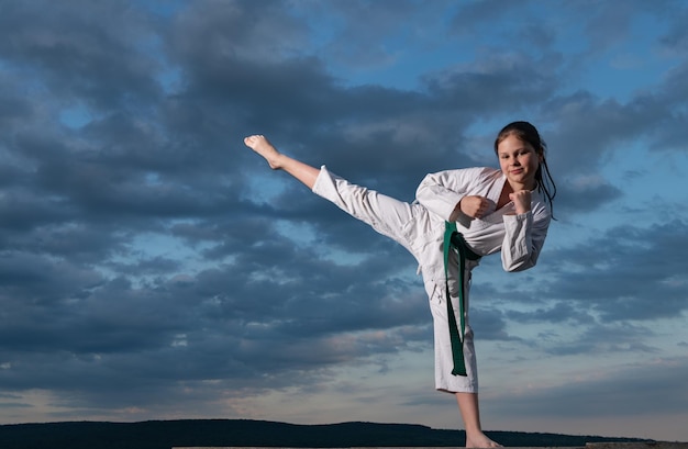 Kungfu-Mädchen im Kimono auf Himmelshintergrund