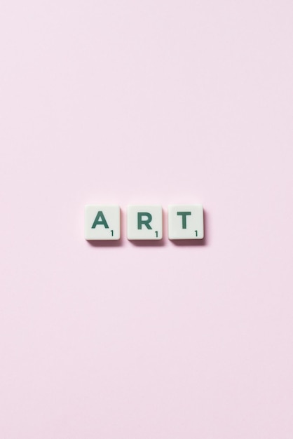 Kunst aus Scrabble-Fliesen auf rosa Hintergrund