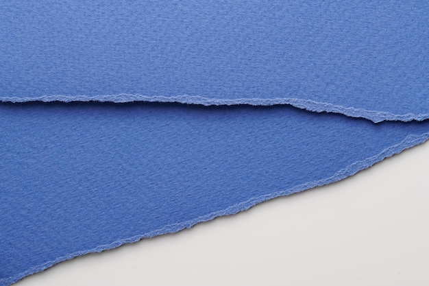 Kunst-Collage aus zerrissenen Papierstücken mit zerrissenen Rändern Klebnoten-Sammlung blau-weiße Farben Stückchen von Notizbüchern Abstrakt Hintergrund
