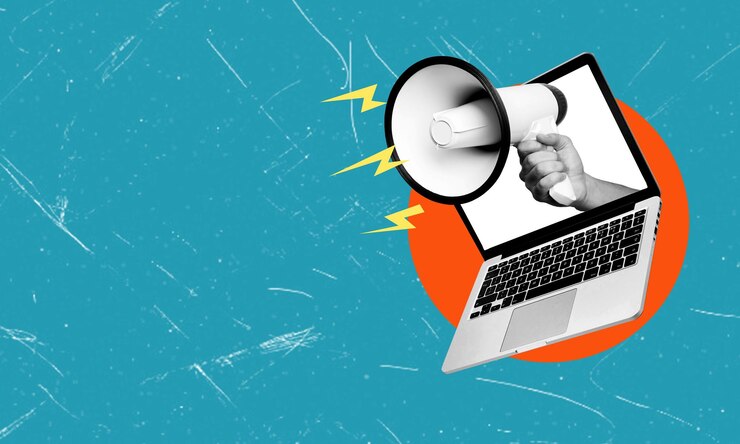 Foto kunstcollage-laptop und megafon auf blauem hintergrund mit kopierraum