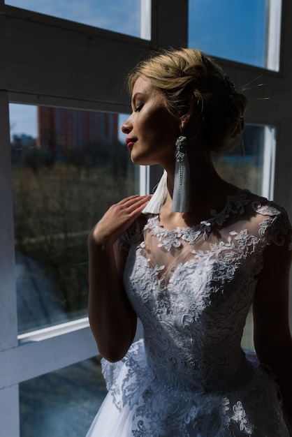 Kunstfoto einer sanften hübschen Frau mit blonder Braut, wunderschönem teurem weißem Kleid