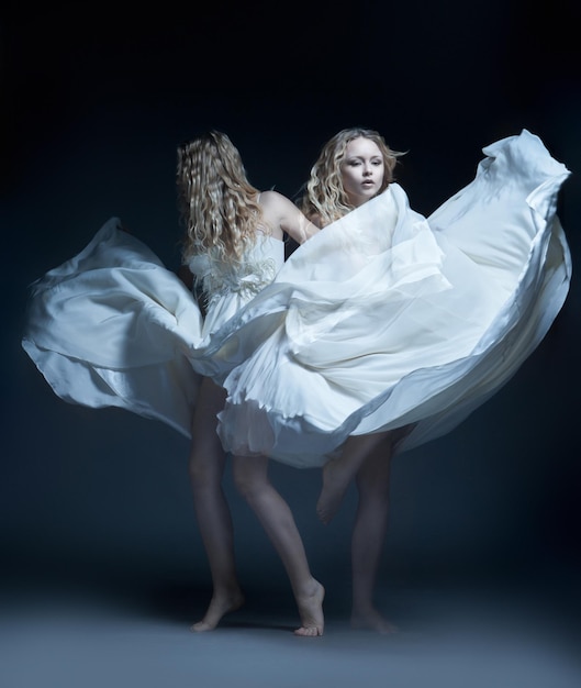 Kunstfoto eines tanzenden schönen jungen Mädchens im weißen Hochzeitskleid mit Mehrfachausstellung