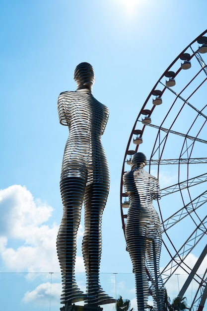 Kunstobjekt bewegliche Figuren eines Paares auf dem Hintergrund des Riesenrads in der Stadt Batumi