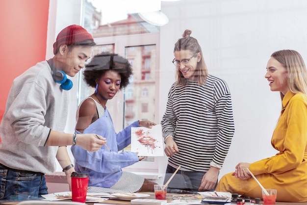 Kunstschule. vier kreative, moderne, gut aussehende schüler der kunstschule, die sich beim malen freuen