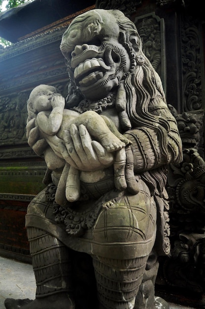 Kunstskulptur und geschnitzter antiker Gottheits-Engelsgott der hinduistischen Statue im balinesischen Stil in Mandala Suci Wenara Wana oder Ubud Sacred Monkey Forest Sanctuary in der Stadt Ubud auf Bali Indonesien