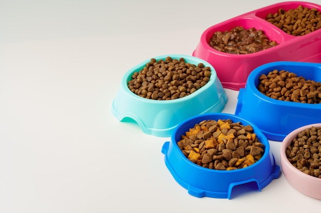 Kunststoffschüsseln für Haustiere mit isoliertem Essen auf weißem Hintergrund