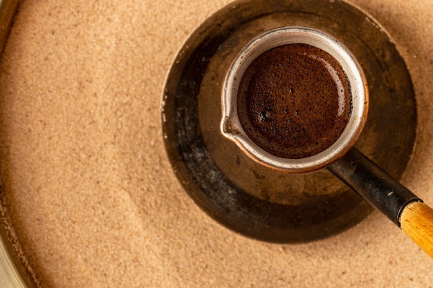 Kupfertürke mit Kaffee, der im Sand brüht