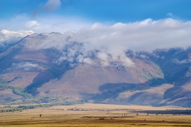 Kurai-Steppe bei Sonnenaufgang. Eine Wolke, die von der Spitze eines Berges kriecht. Republik Altai, Russland