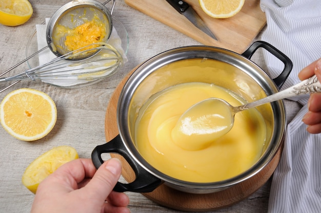 Kurd de limón recién preparado: natillas con jugo de frutas, en una cacerola, revuelva con una cuchara