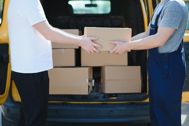 Kurierdienst für die Zustellung von Waren Expressdienst ein Mann in Uniform liefert Kisten aus Der Mitarbeiter trägt die Bestellung nach Hause zum Kunden