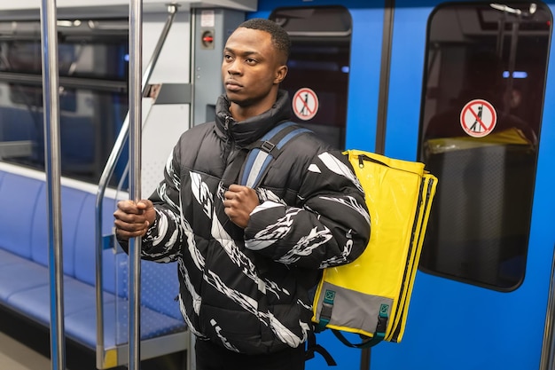 Kurierdienst in der Stadt Pizzalieferant in der U-Bahn Afroamerikanischer Lieferbote
