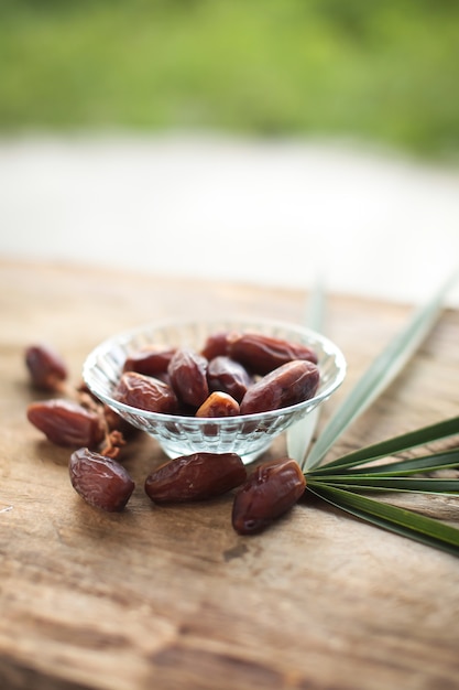 Kurma o fechas secas, rosario sobre fondo de madera.