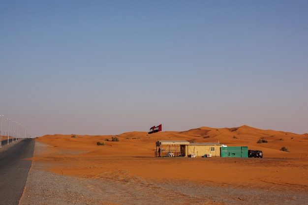 Foto kurvenreiche schwarze asphaltstraße durch sanddünen