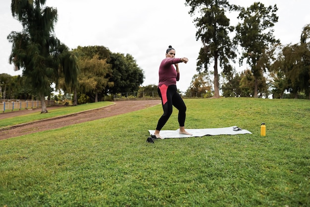 Kurvige Frau, die Workout-Boxroutine im Freien am Stadtpark tut - Fokus auf Gesicht