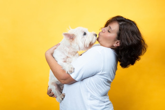 kurvige Frau im gelben Hintergrund mit ihrem Hund